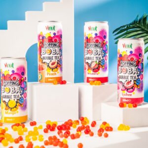 Four cans of Vinut Popping Boba Bubble Tea in mango, peach, strawberry, and lychee flavors are displayed on white platforms, surrounded by colorful popping boba beads.