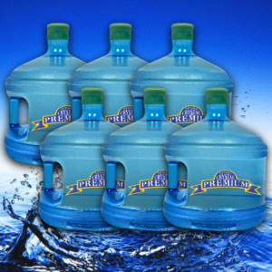 Six large blue water jugs labeled "Crystal Premium" are arranged together on a blue background with water splashing at the bottom, evoking the pure freshness of spring. Perfect for your Bottle Plan, these premium jugs ensure you always have crisp, refreshing water on hand.